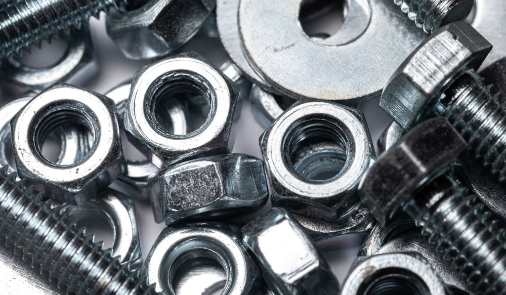 A Pile of Nuts and Bolts on A White Surface — Border Bolts & Fasteners in Tweed Heads South, NSW