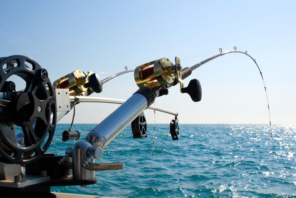 Three Fishing Rods Are on A Boat in The Ocean — Border Bolts & Fasteners in Tweed Heads South, NSW
