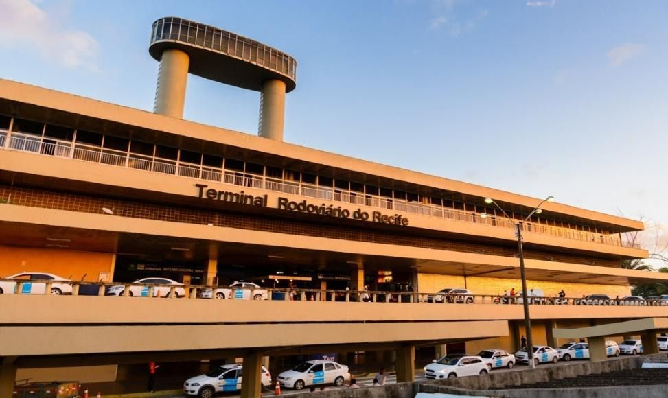 Terminal Rodoviário da Bahia bus station with taxis in front, under a sunny sky.