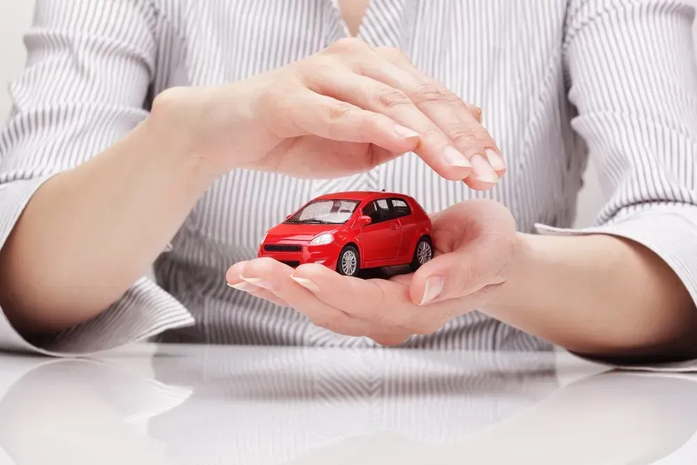 Hands Cupping a Small Red Toy Car, Implying Protection or Insurance — Coastal Collision Repairs in Buderim, QLD