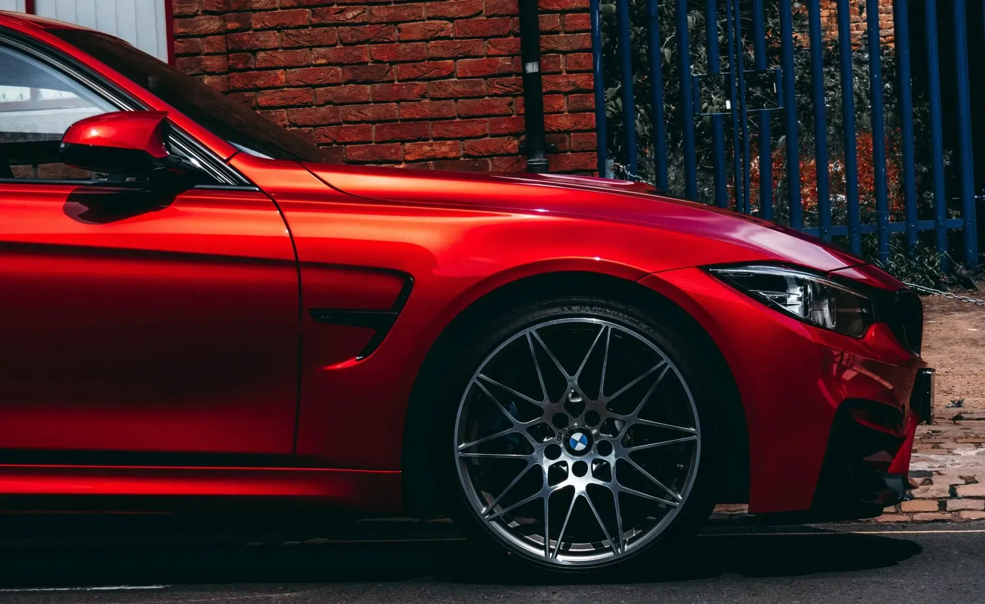 Red BMW Sports Car Parked Next to a Brick Wall and a Blue Fence — Coastal Collision Repairs in Buderim, QLD