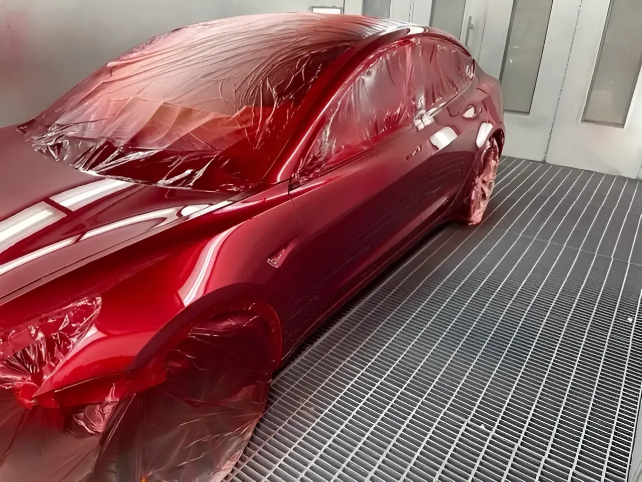 Red Tesla Car Being Painted in a Spray Booth — Coastal Collision Repairs in Buderim, QLD