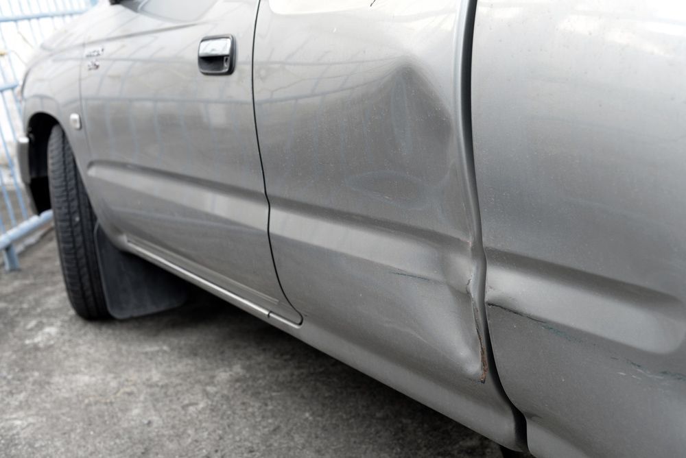 Silver Car with Dent on Left Side