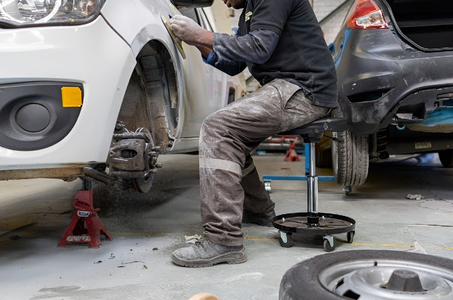 Technician Repairing Damaged Car Panel During Smash Repair Process