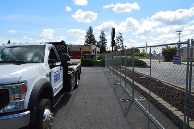Truck parked beside a chain-link fence on a sunny roadside with railroad tracks nearby Truck parked beside a chain-link fence on a sunny roadside with railroad tracks nearby