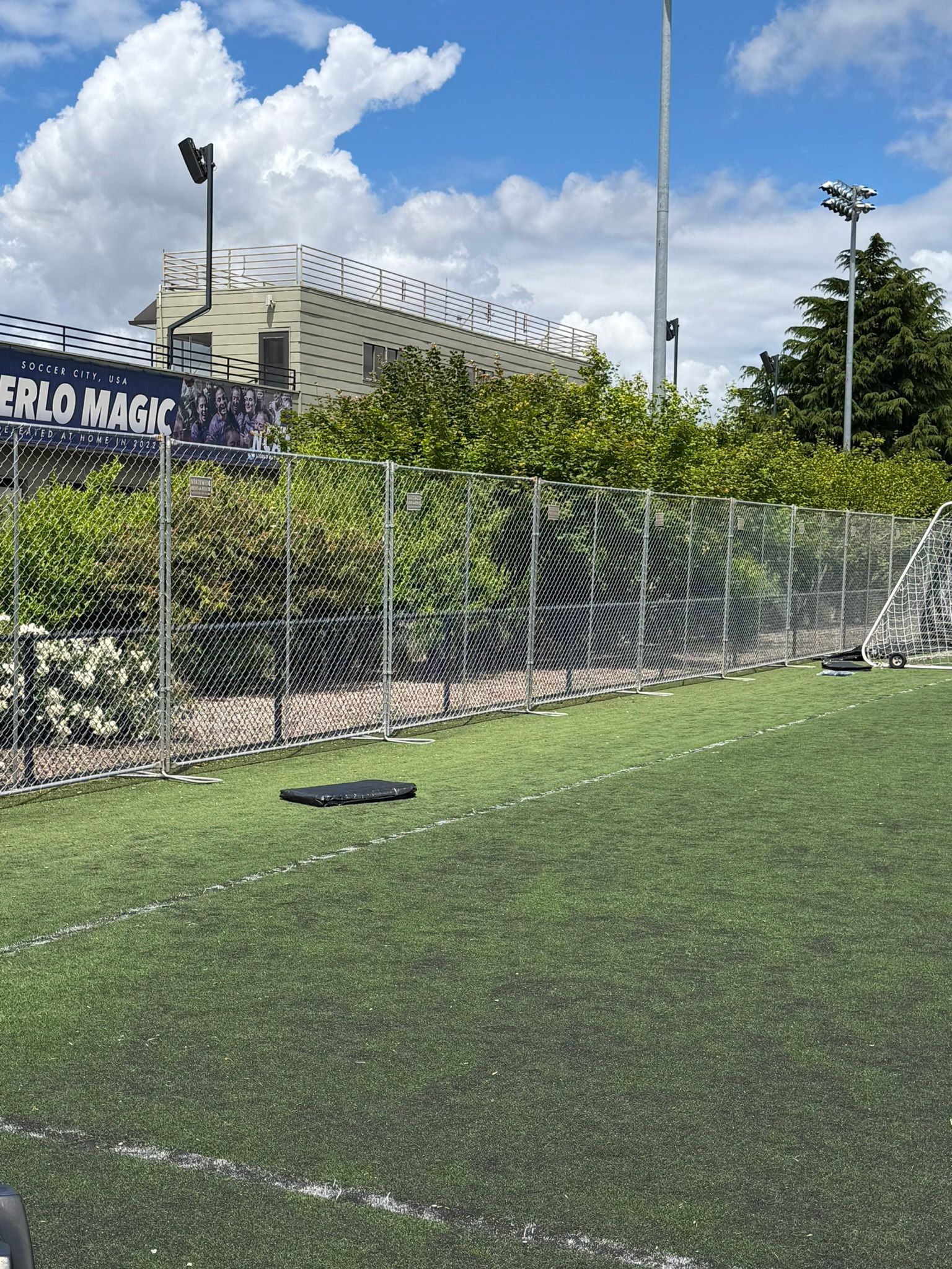 Green chain-link fence with metal posts in a grassy outdoor area Green chain-link fence with metal posts in a grassy outdoor area
