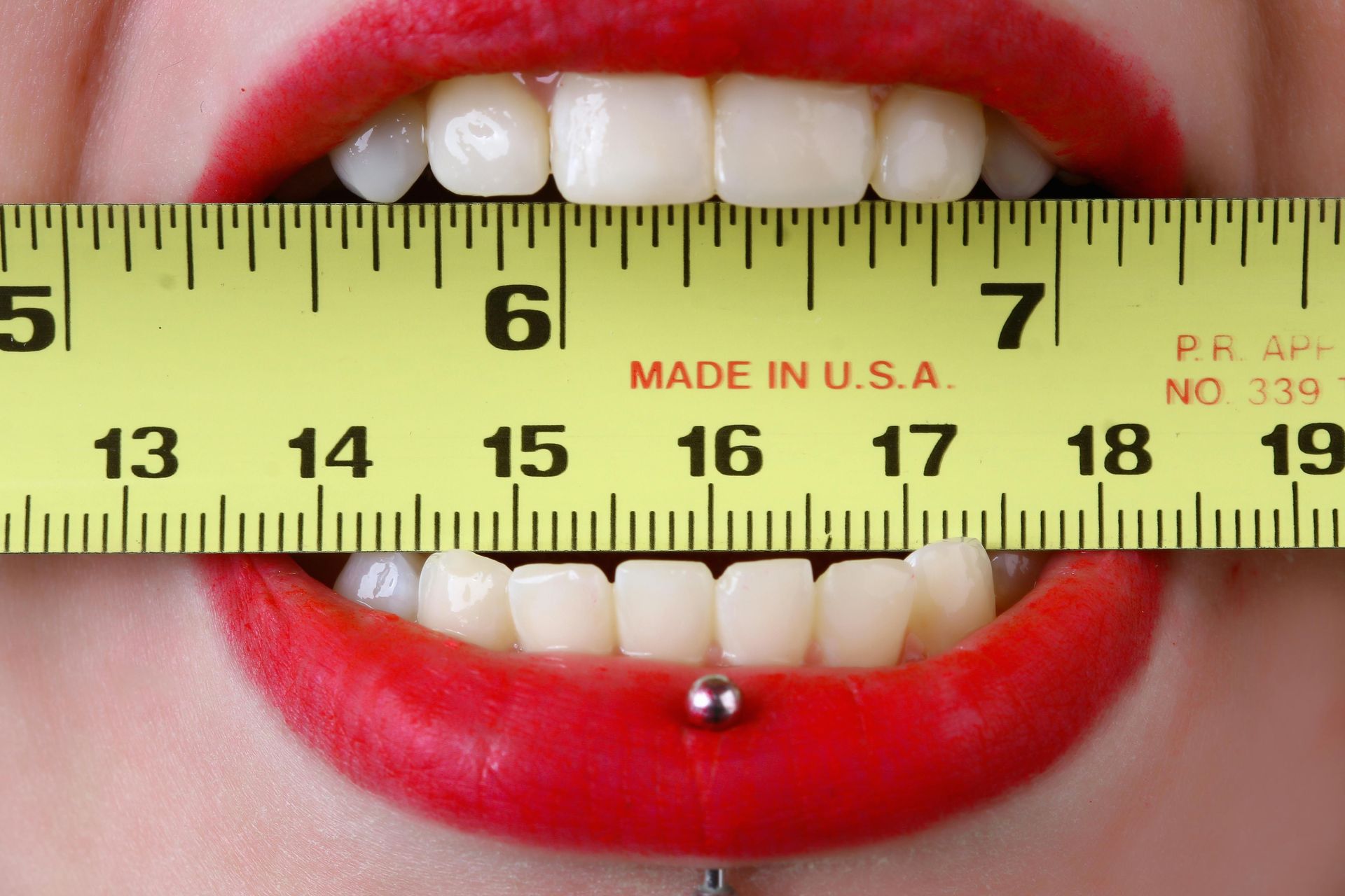 A woman is measuring her teeth with a ruler made in the usa