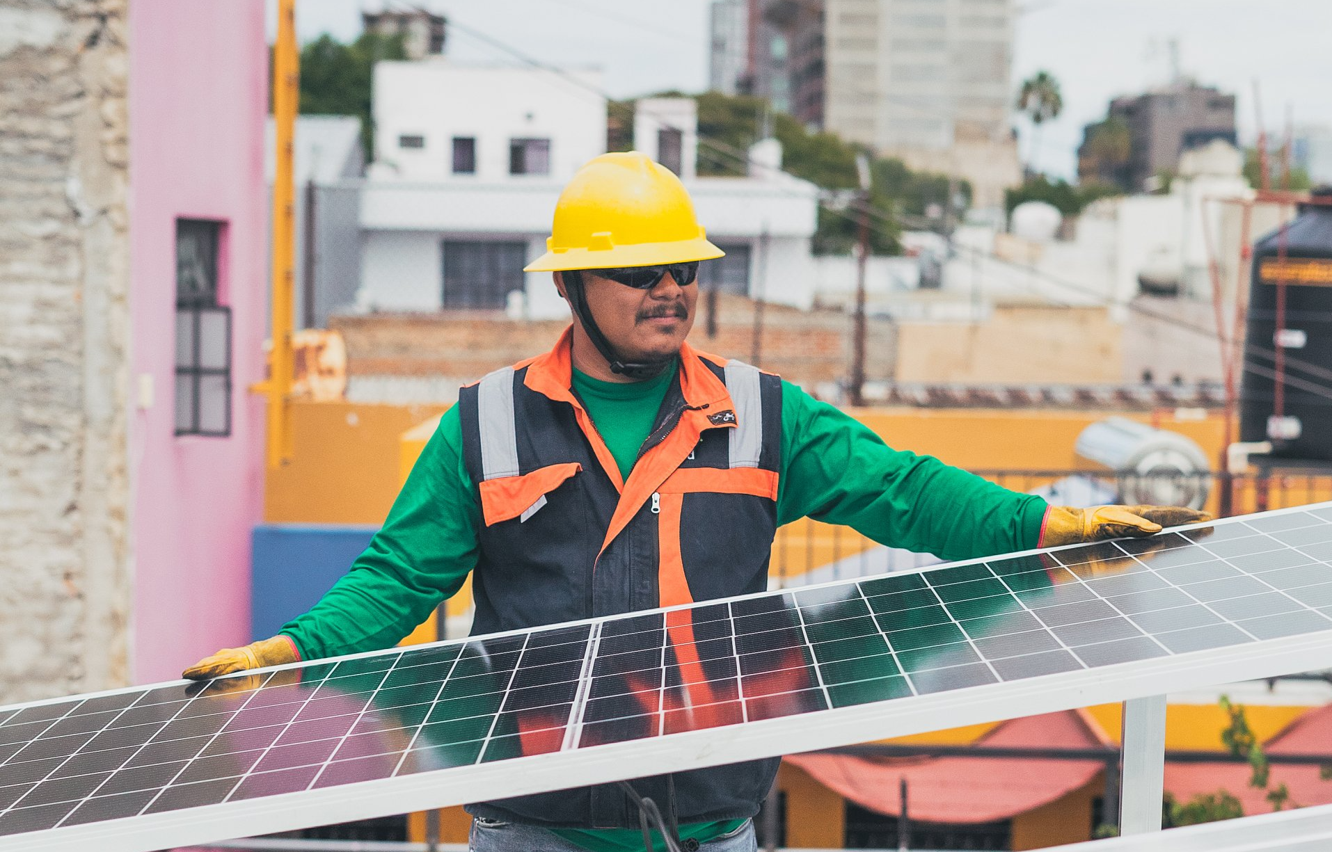 electrician  installing solar panels on top of a industrial factory