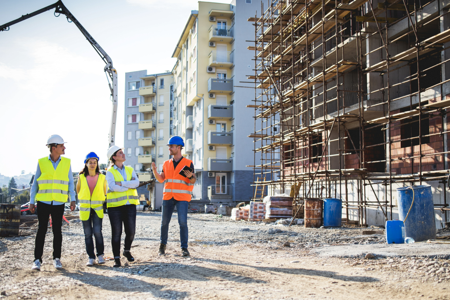 construction workers and architects talking along building that is under construction