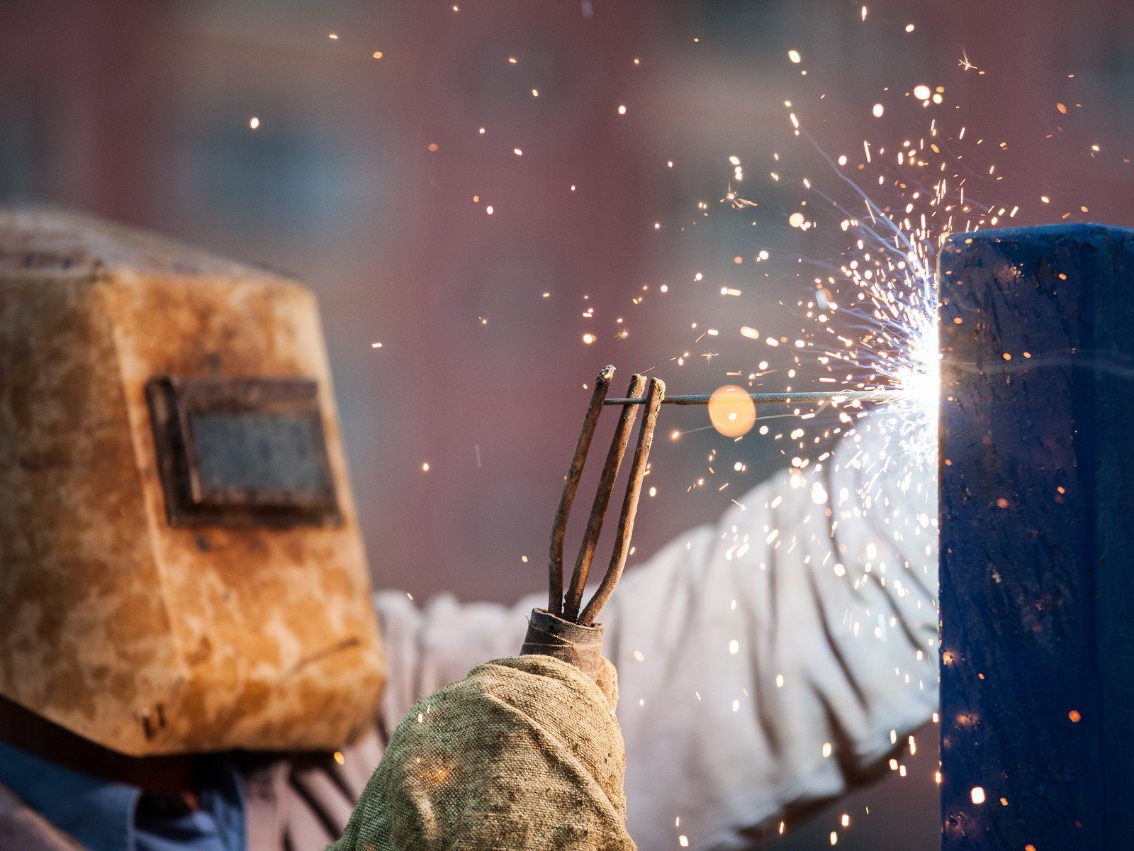 worker using the welding machine in the metal