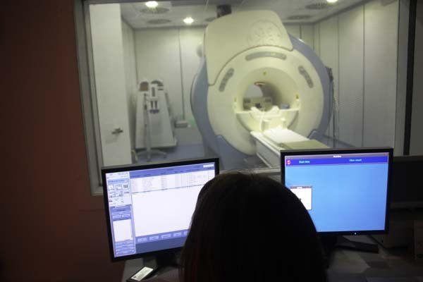 Una persona sta guardando uno schermo di computer davanti a una macchina per la risonanza magnetica