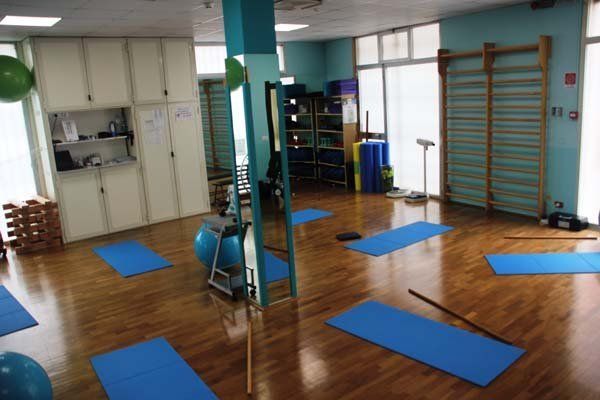 Una palestra con tappetini blu e una palla da pilates