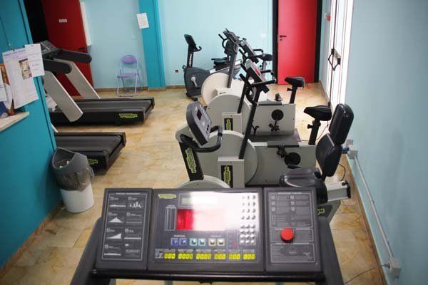 Una fila di tapis roulant e cyclette in una palestra