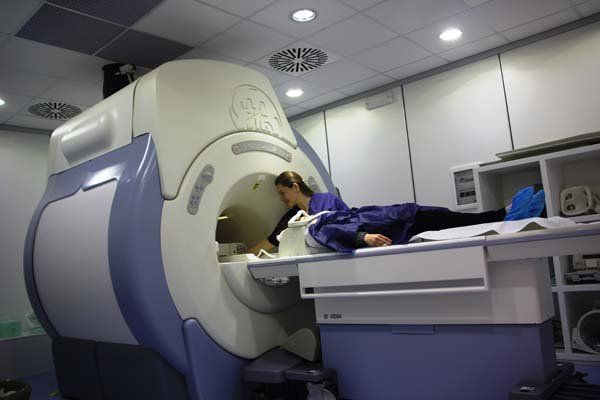 Una donna è sdraiata su un letto davanti a una macchina per la risonanza magnetica.