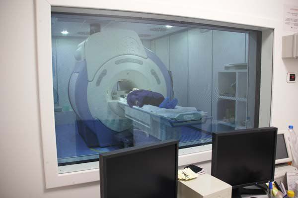 Una persona è sdraiata su una macchina per la risonanza magnetica in una stanza d'ospedale.