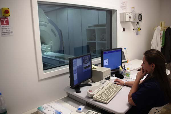 Una donna è seduta a una scrivania davanti a due monitor di computer