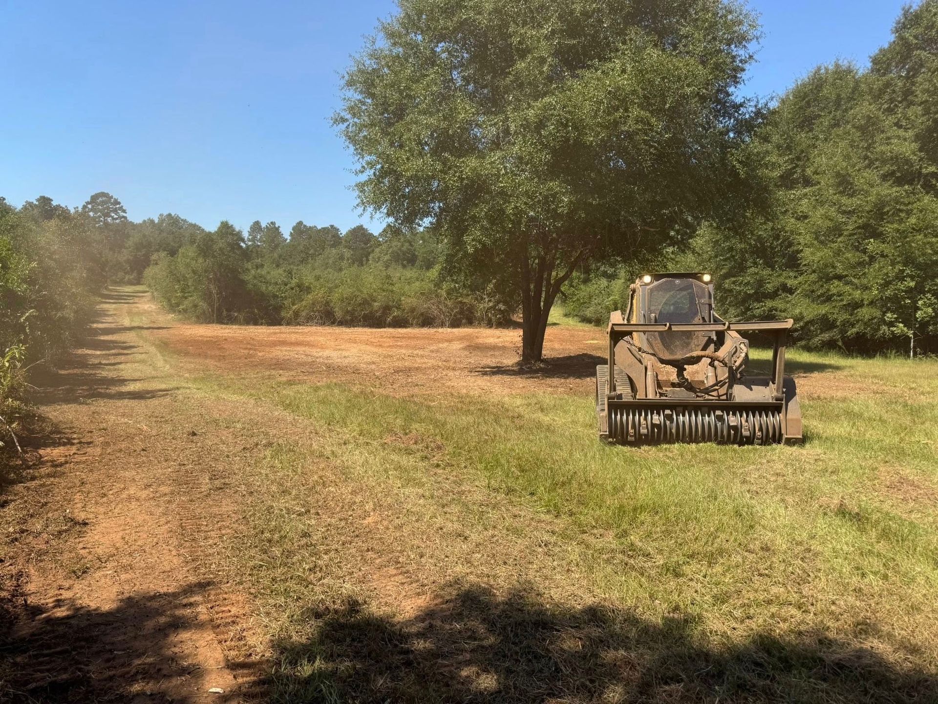 Night view of a yellow construction roller on a freshly laid road. Headlights illuminate the textured surface.