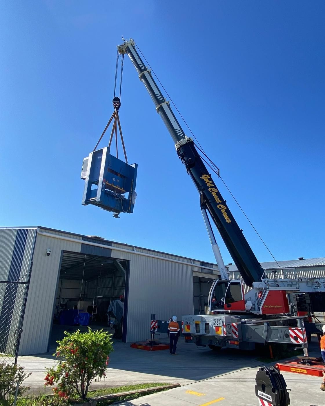A Crane is Lifting a Machine Into a Building — Mbah Metal Roofing in South Lismore, NSW