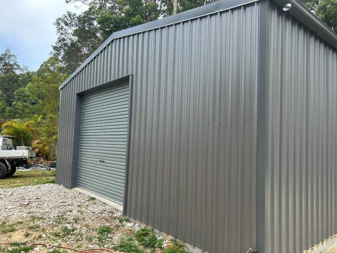 A Gray Metal Building With a White Truck Parked in Front of It — Mbah Metal Roofing in South Pottsville, NSW