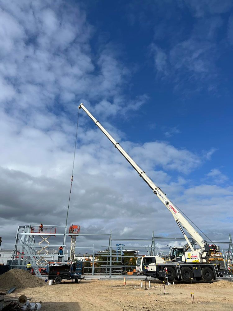 A Large Crane is Being Used to Lift a Metal Structure on a Construction Site — Mbah Metal Roofing in South Ballina, NSW