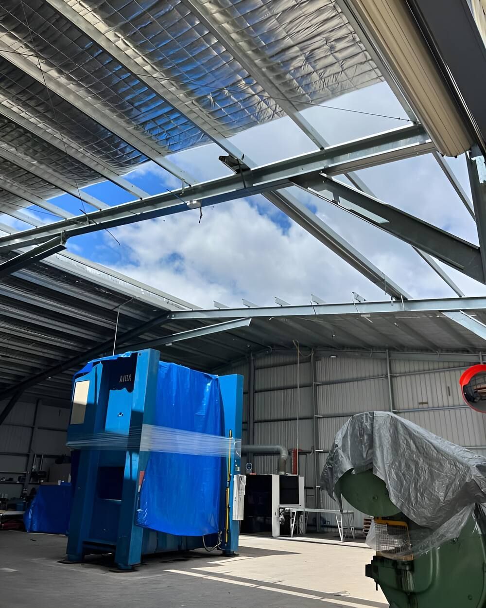 A Large Blue Machine Is Sitting Inside Of A Building — Mbah Metal Roofing In Murwillumbah, NSW