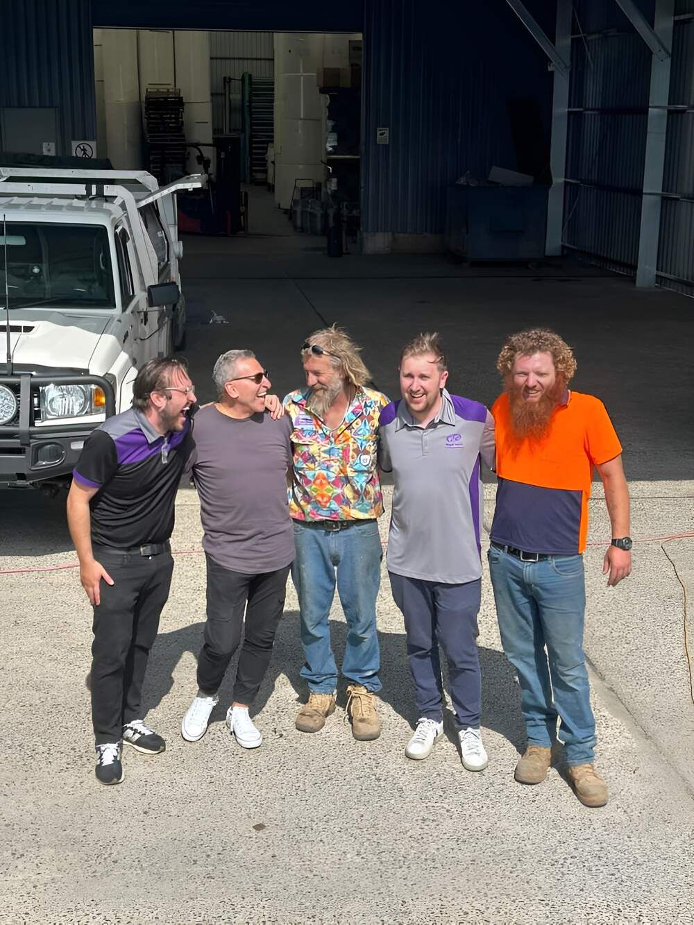 A Group Of Men Are Posing For A Picture In Front Of A Truck — Mbah Metal Roofing In Murwillumbah, NSW