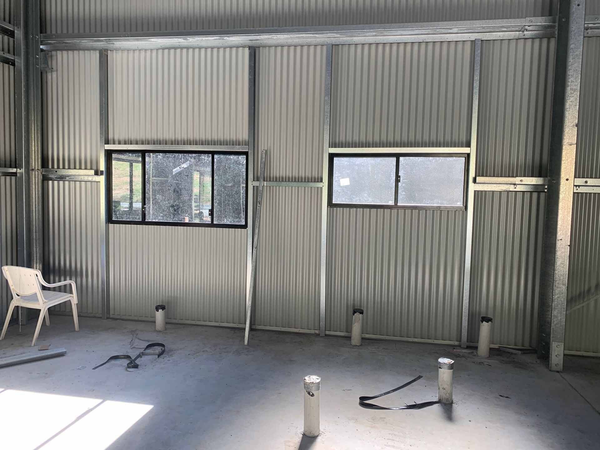An Empty Room With A Chair And A Window — Mbah Metal Roofing In Murwillumbah, NSW