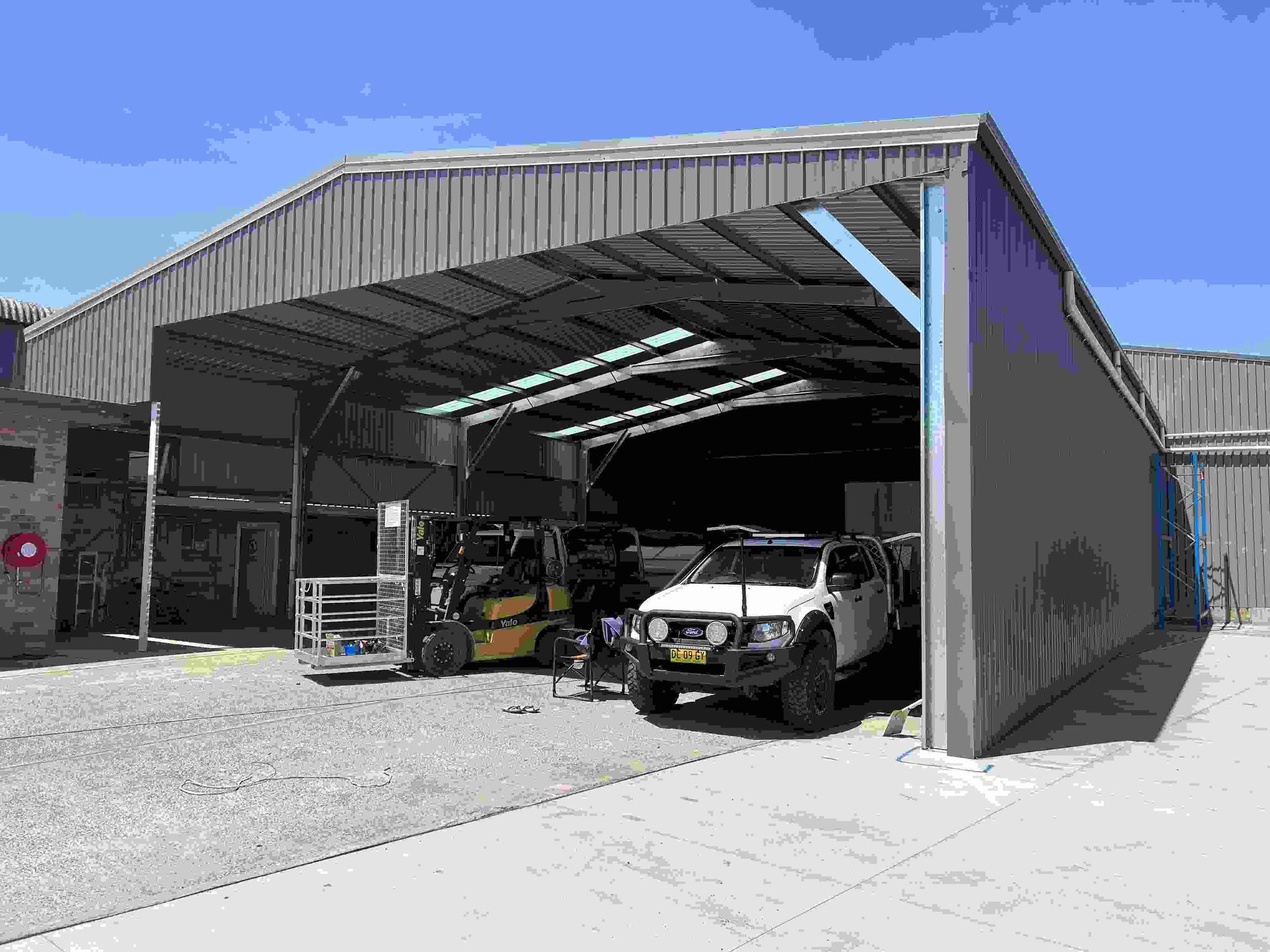 A Truck Is Parked In A Garage Under A Roof — Mbah Metal Roofing In Murwillumbah, NSW
