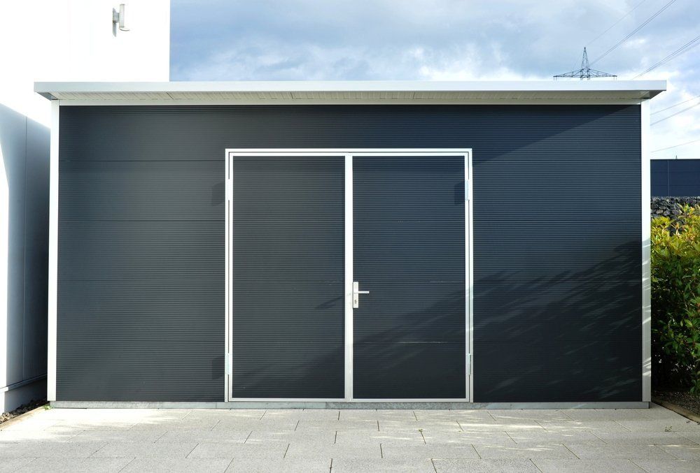 A Black Garage With Two Doors And A Roof — Mbah Metal Roofing In Murwillumbah, NSW.
