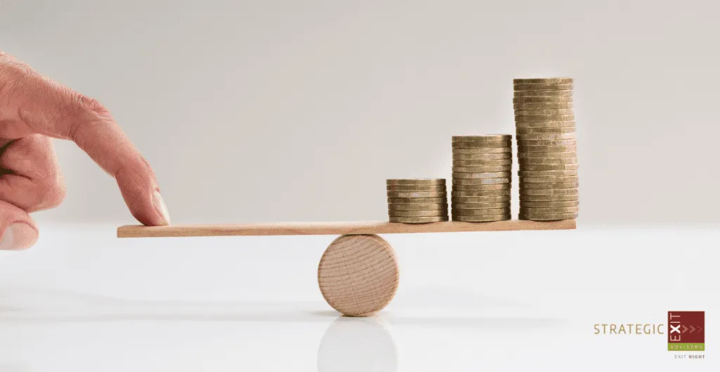 Hand balancing a wooden seesaw with stacks of coins, representing financial growth.