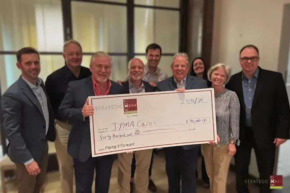 Group of people holding an oversized check for $5,900.00, likely a donation.