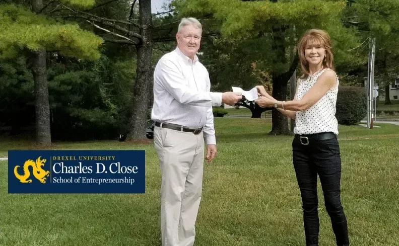 Man handing woman keys outdoors; WKU logo in the lower-left corner.