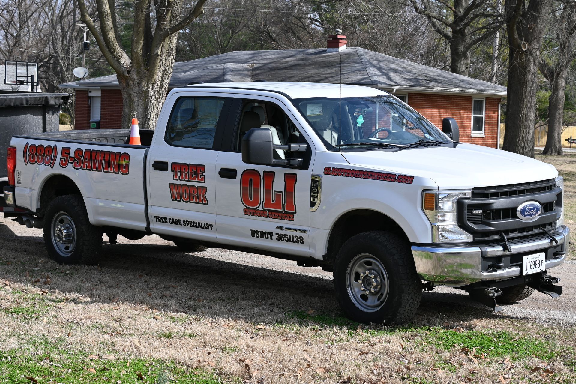 A white ford truck is parked in front of a house.