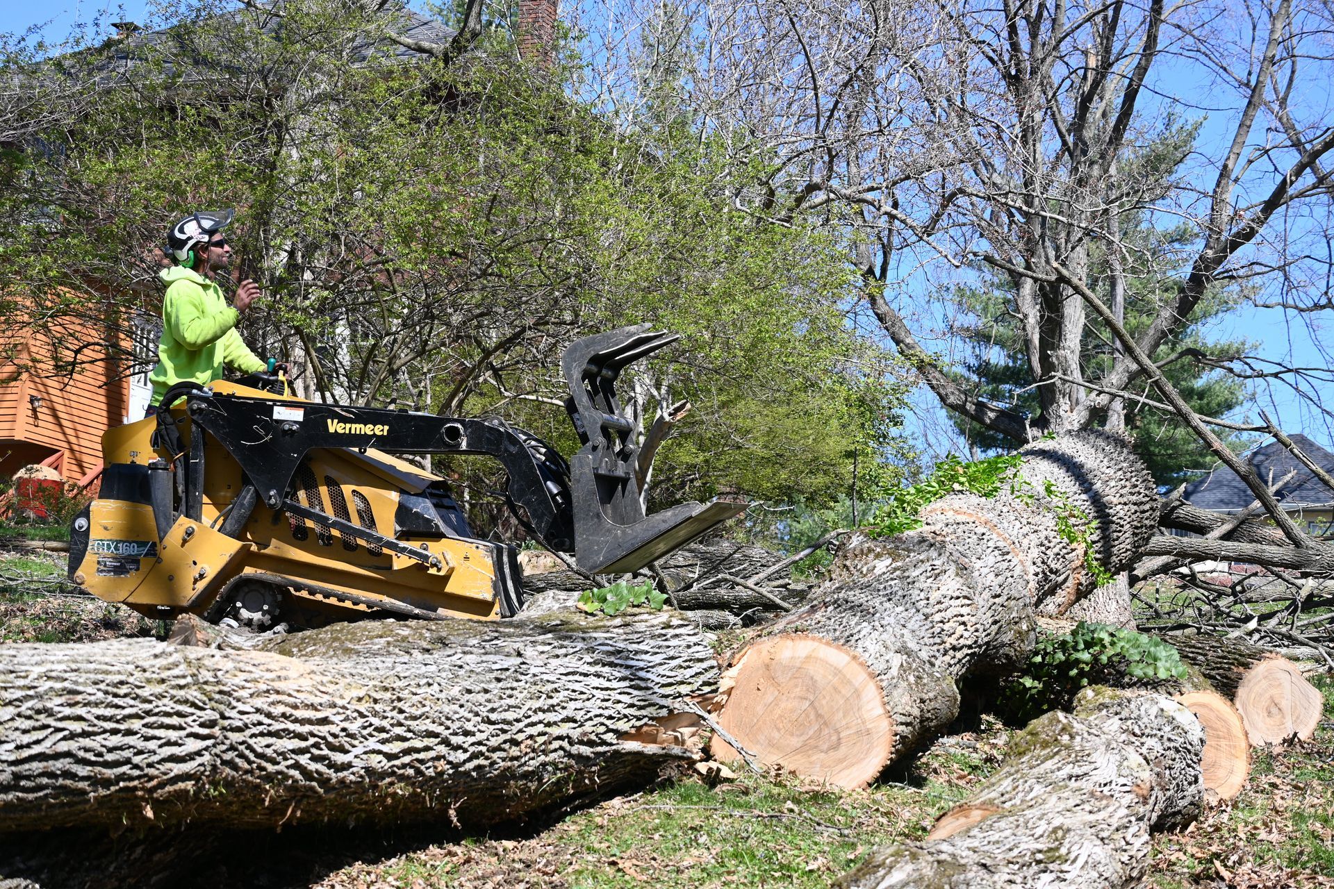 A man is driving a bulldozer over a large log.