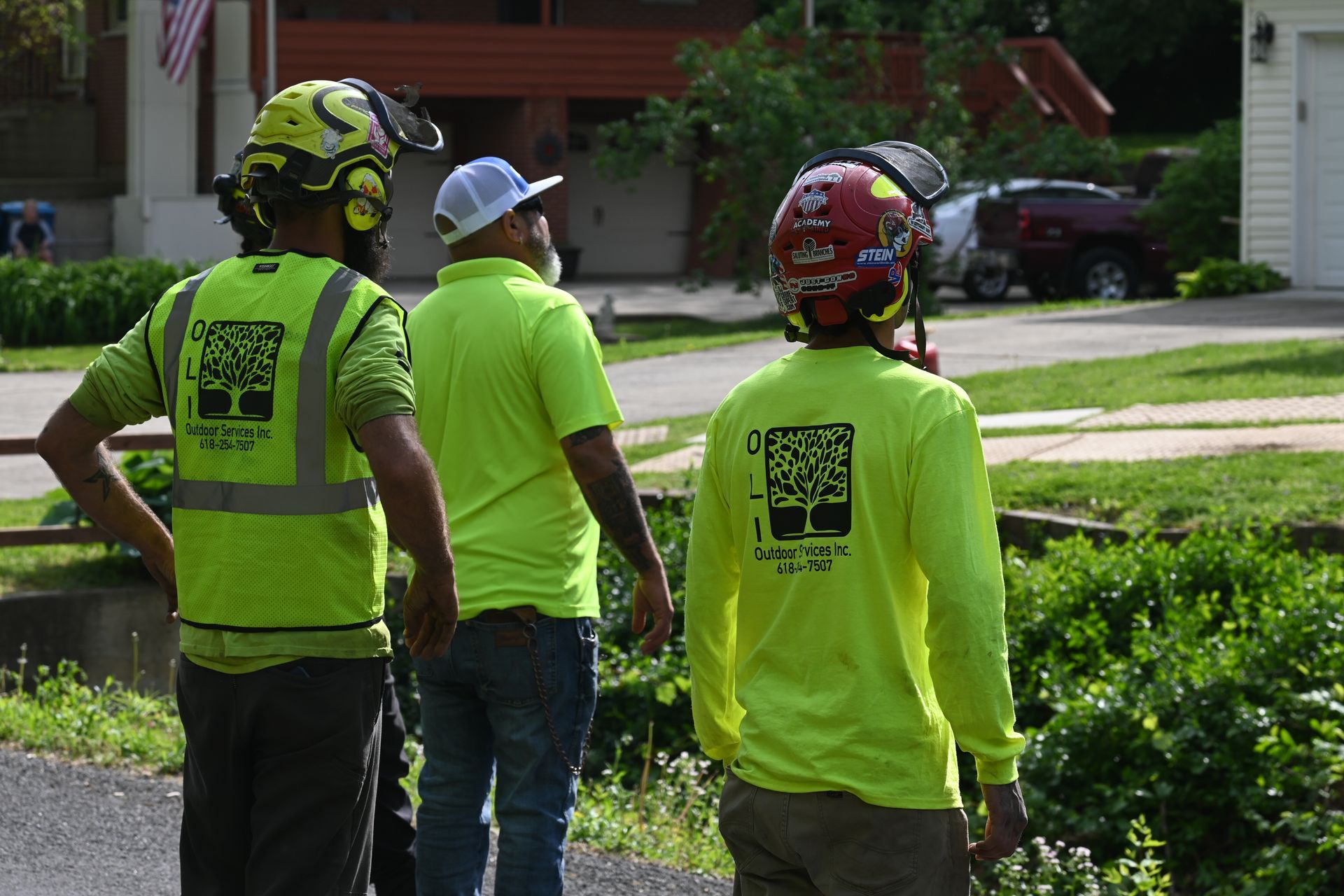 A group of people wearing safety vests and helmets are walking down a street.