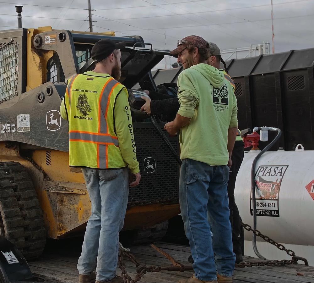 A group of men are standing in front of a john deere tractor