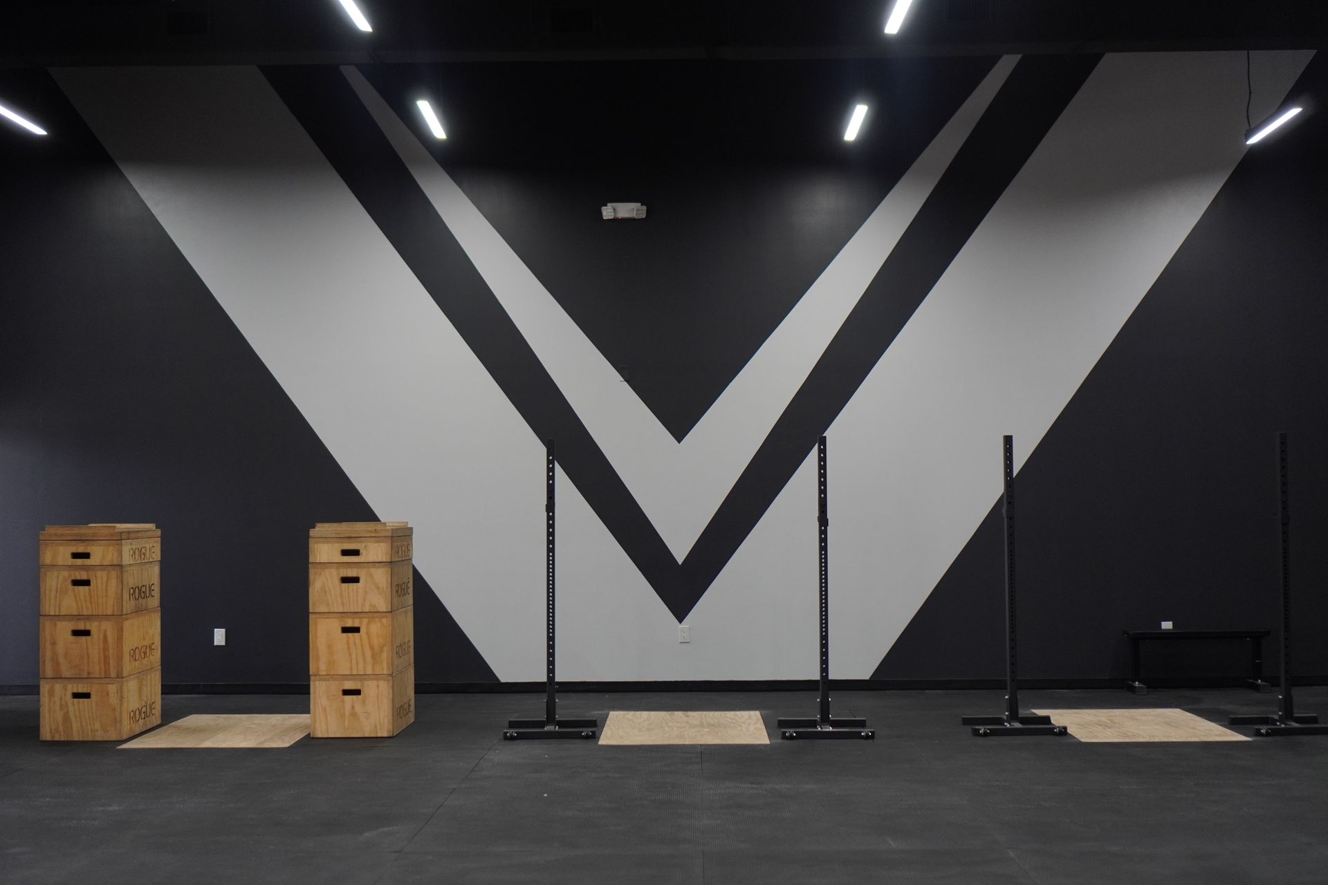 a man is lifting a barbell in a gym .