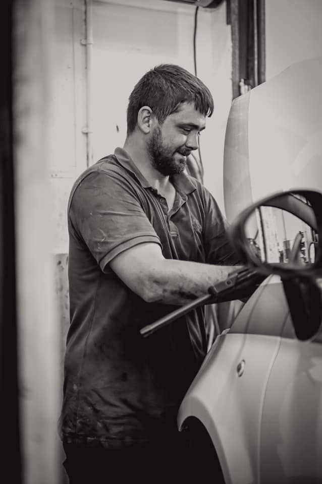 black and white image of a man doing a car service