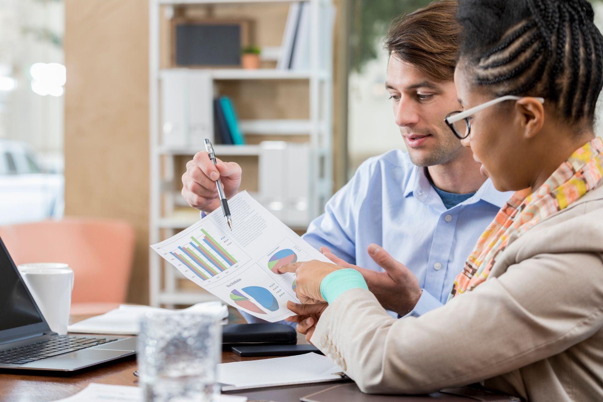 man showing woman financials on a paper