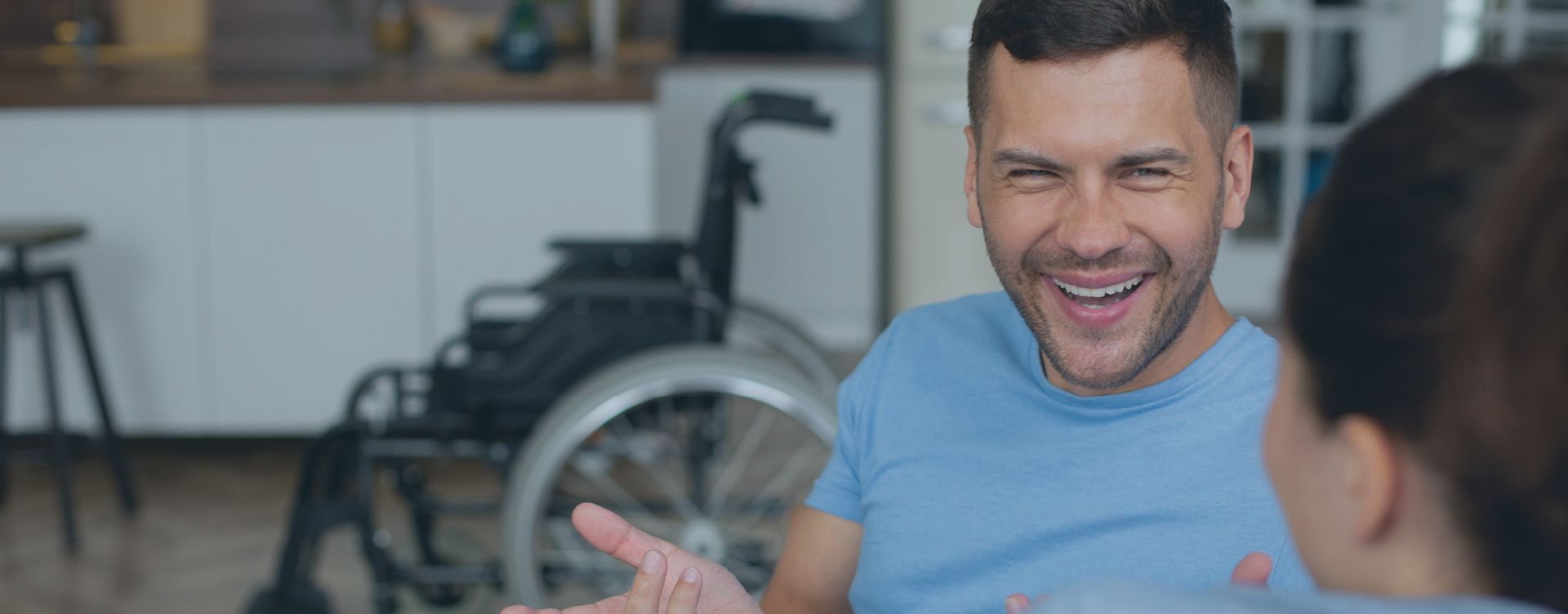 A man in a wheelchair is talking to a woman.