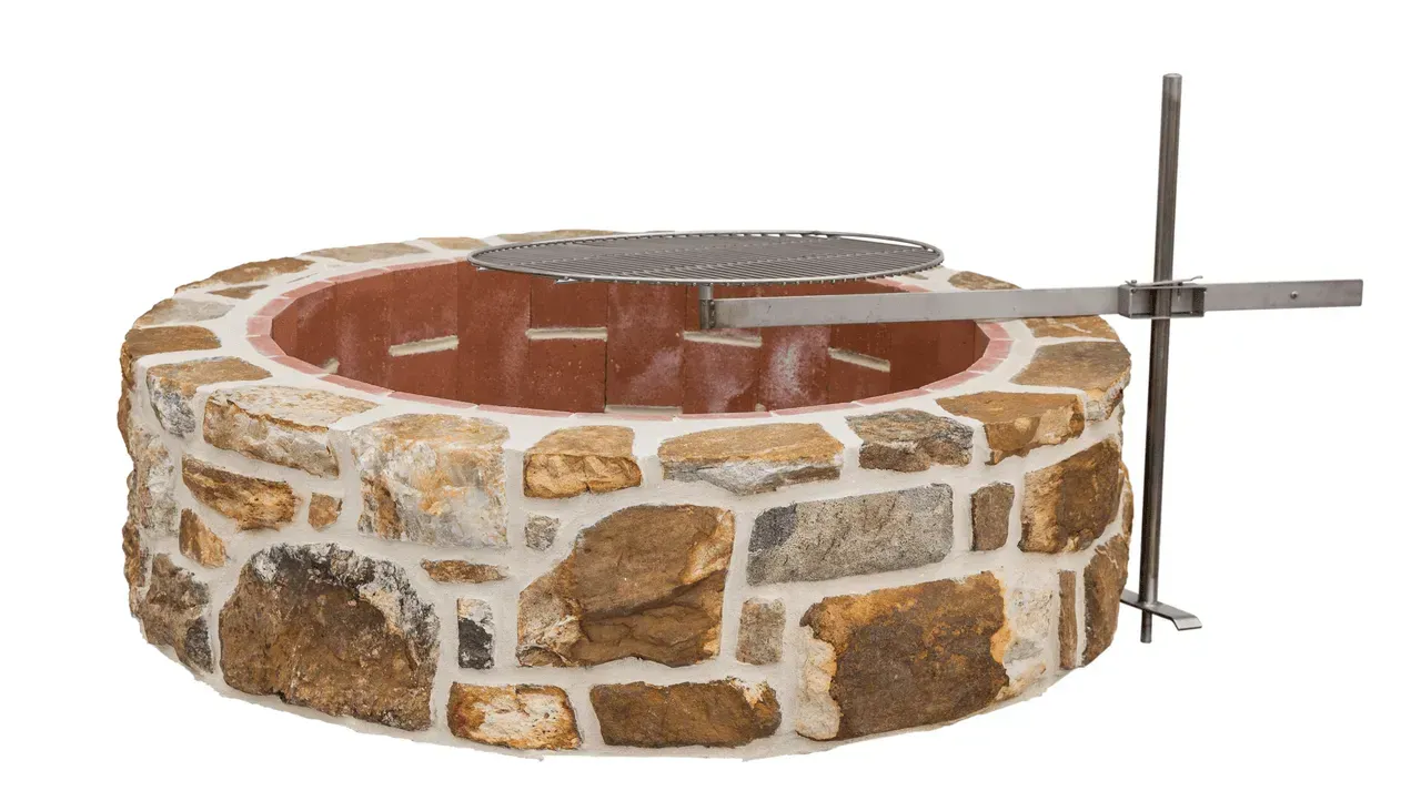 A stone fire pit with a grill attached to it on a white background.