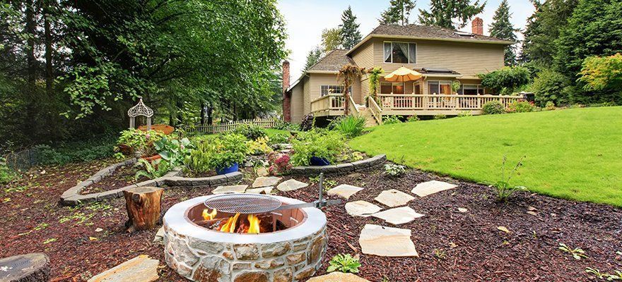 There is a fire pit in the backyard of a house.