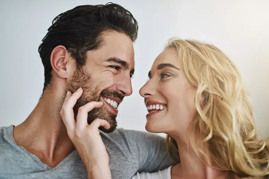 A man and a woman are looking at each other and smiling.