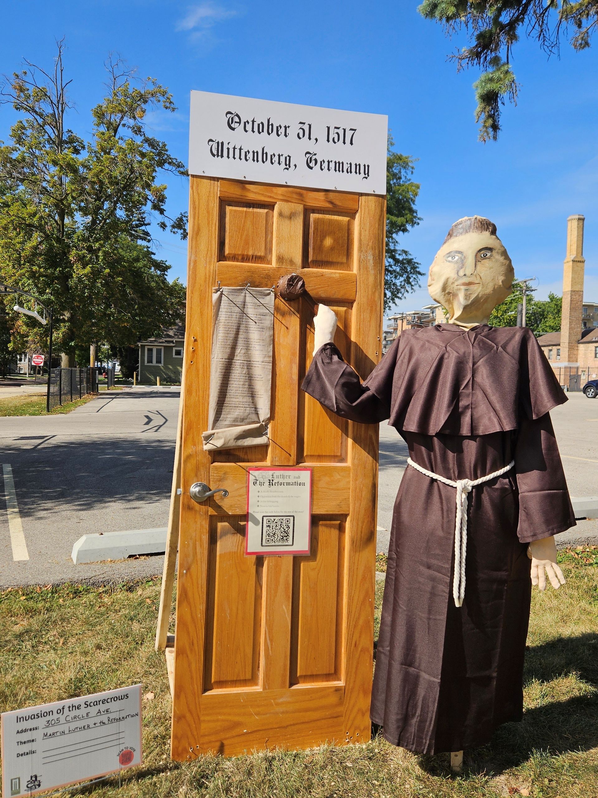 Woman tending a rectangular raised garden bed of vegetables, in a green yard.