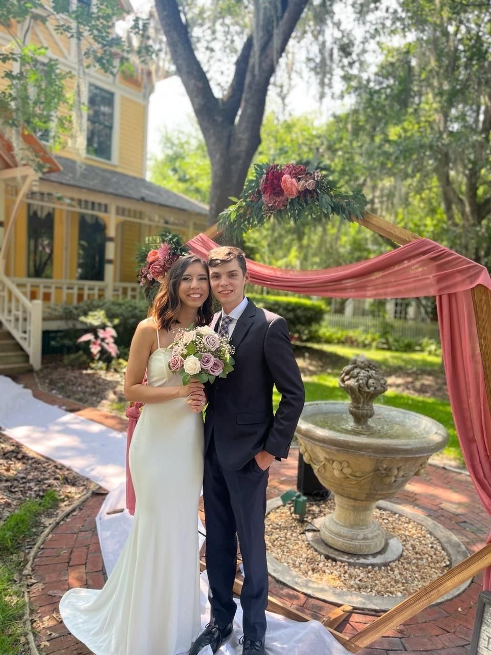 A bride and groom next to the fountain at The laurel Oak Inn.