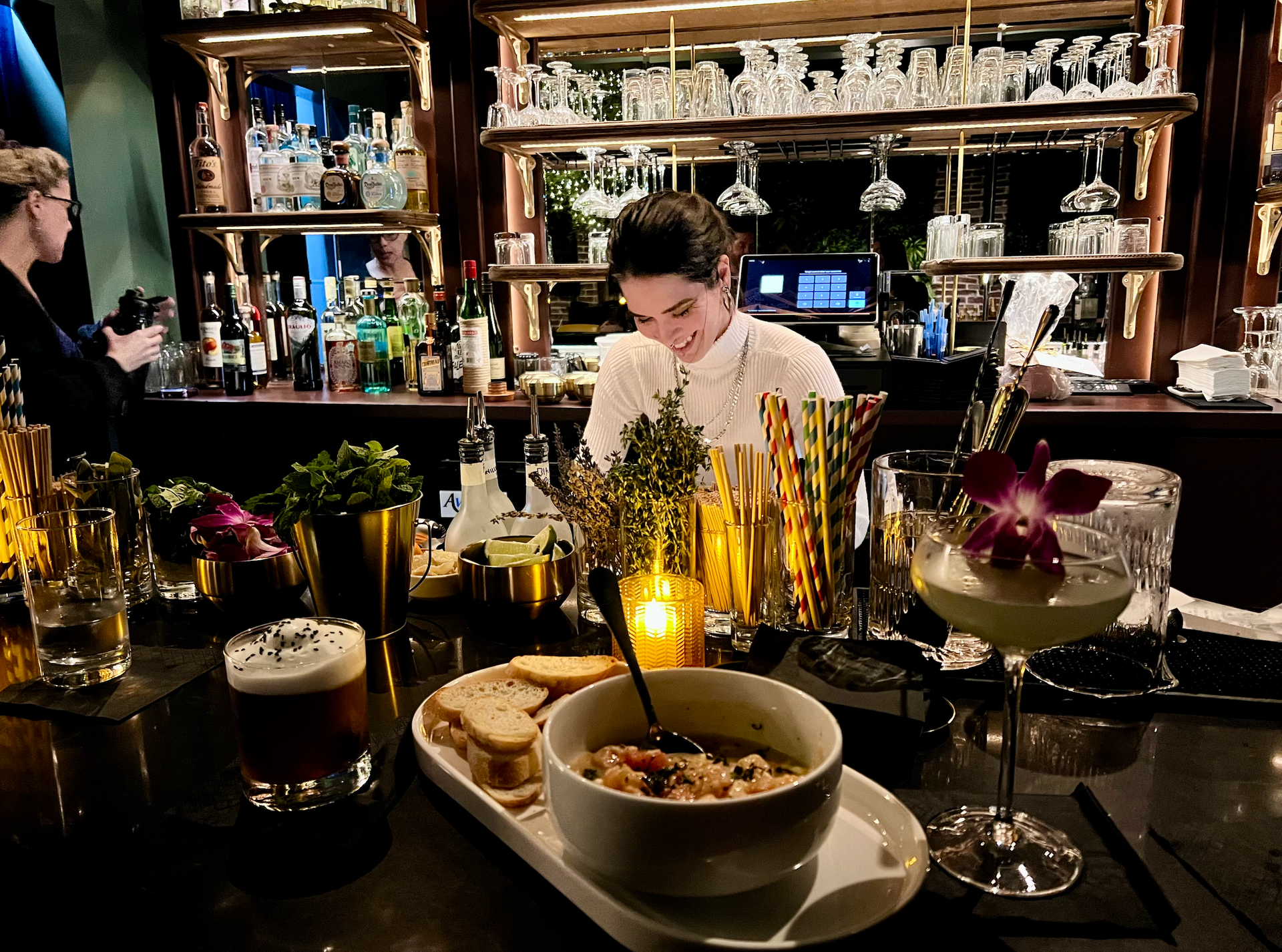 Bartender behind a bar preparind drinks and food at Kin Lounge in downtown Gainesville FL
