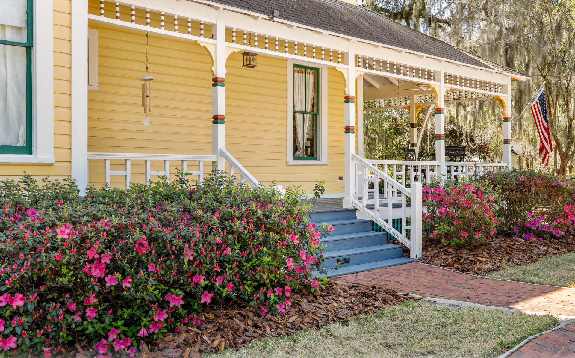 Front porch of yellow Victorian home