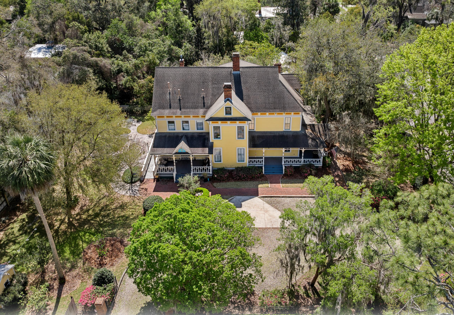 Aerial view of yellow Victorian - AirBNB, STR, and Vacation Rental