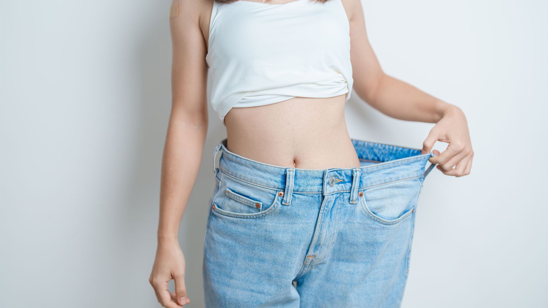 A woman is wearing a pair of very large jeans.