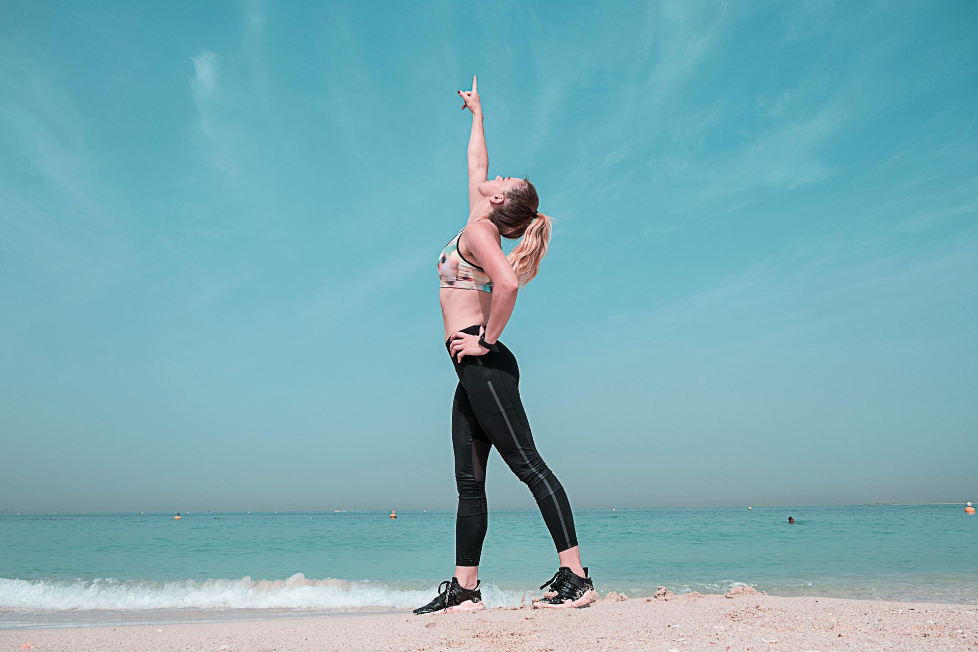 A woman is doing yoga on the beach.